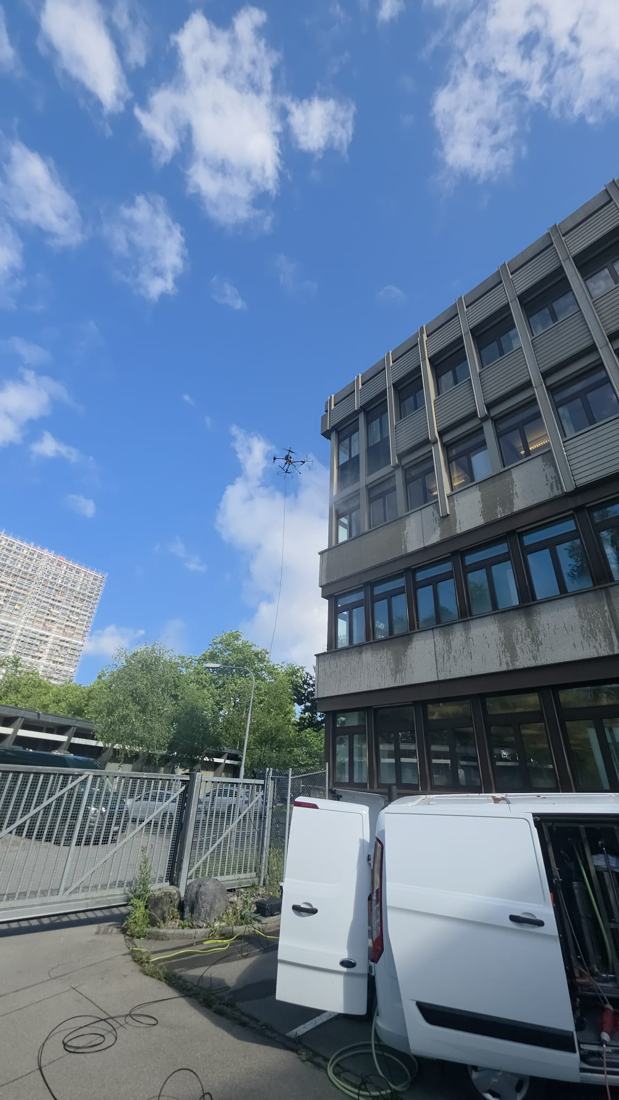 Drohneneinsatz an Bürogebäude mit Einsatzfahrzeug